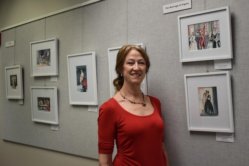 Kathryn Peterson with paintings she created during San Diego Opera rehearsals of “Carmen” and “The Marriage of Figaro.”