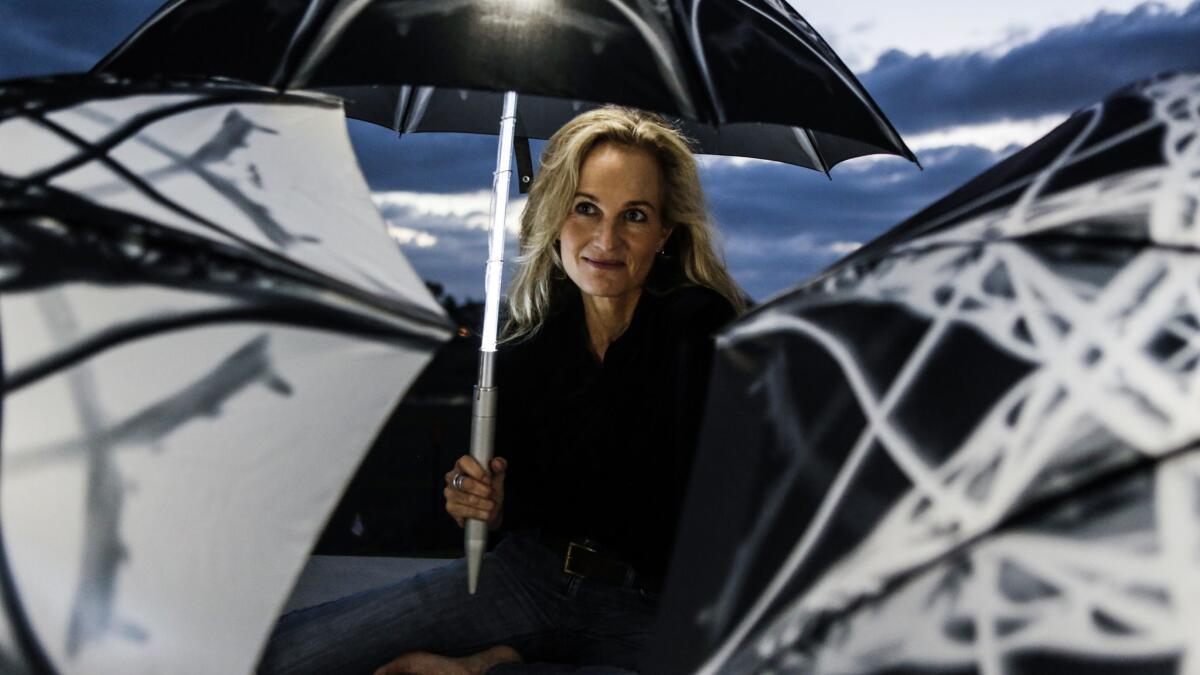 Artist Elizabeth Turk displays one of her light-up umbrellas that will be used in an evening performance on a Southern California beach.