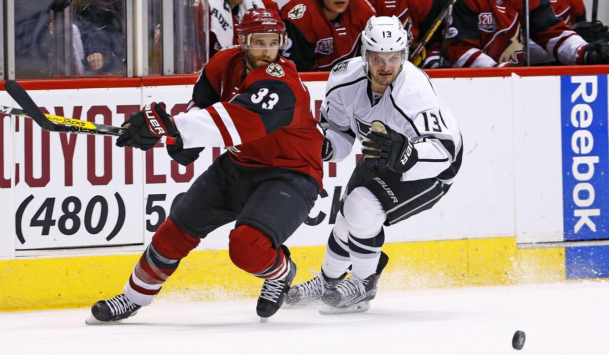Arizona Coyotes defenseman Alex Goligoski (33) and Kings left wing Kyle Clifford (13) go after the puck during the first period Tuesday.