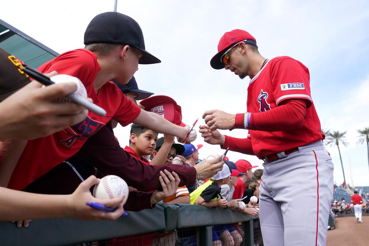 Angels shortstop prospect Zach Neto signs autographs before a spring training game in March.