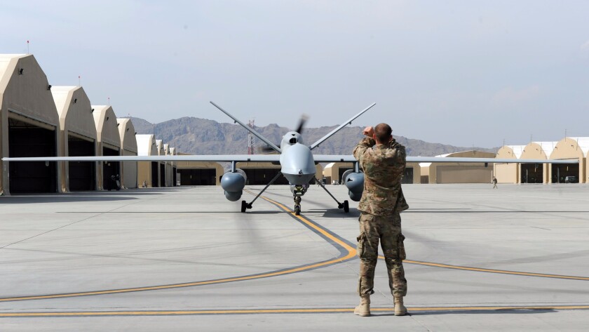 An Airman marshals an MQ-9 Reaper drone to the runway prior to launch on March 20, 2015, at Kandahar Airfield, Afghanistan.