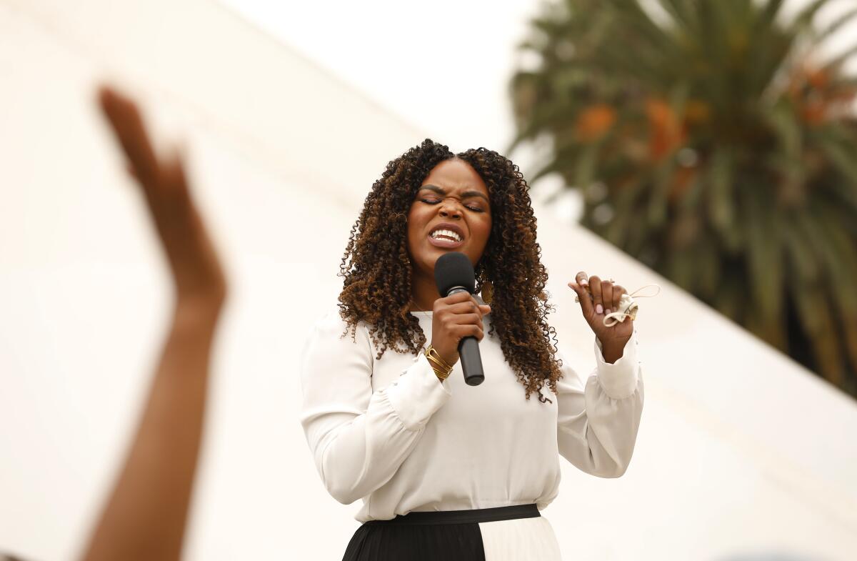 Compton Mayor Aja Brown leads a crowd in prayer 