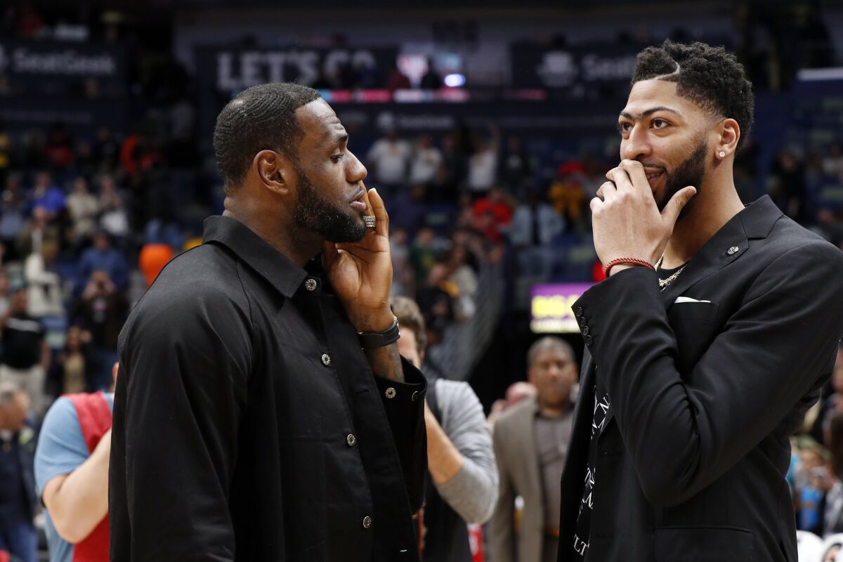 Lakers forward LeBron James, left, and Anthony Davis, then forward-center for the Pelicans, chat after a game March 31.