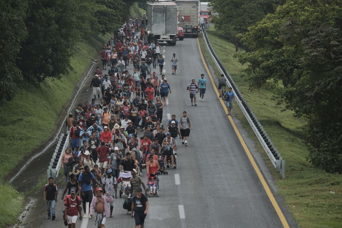 Migrants leave Ulapa, Chiapas state, late Saturday, Oct. 30, 2021. The migrant caravan heading north in southern Mexico has so far been allowed to walk unimpeded, a change from the Mexican government's reaction to other attempted mass migrations. (AP Photo/Isabel Mateos)