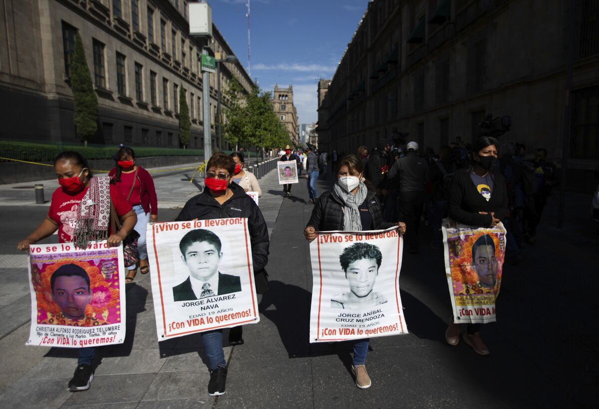 Mujeres con fotografías de sus familiares desaparecidos, que se encuentran entre los 43 estudiantes de una escuela de maestros en el estado sureño de Guerrero