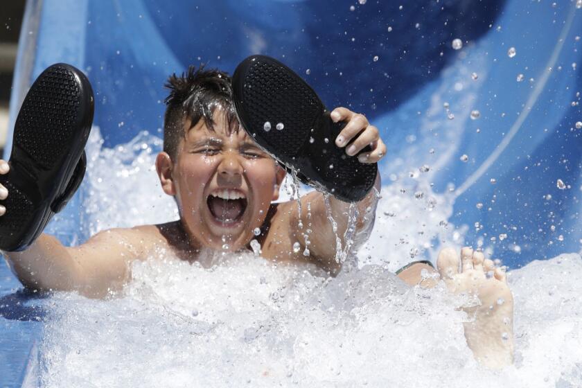 ROSEMEAD, CA -- JULY 06, 2018: Angel Escobedo, 11, celebrates his birthday and fights the heat with a ride down the water slide at Splash Zone in Rosemead. The temperature this day was 109 degrees. (Myung J. Chun / Los Angeles Times)