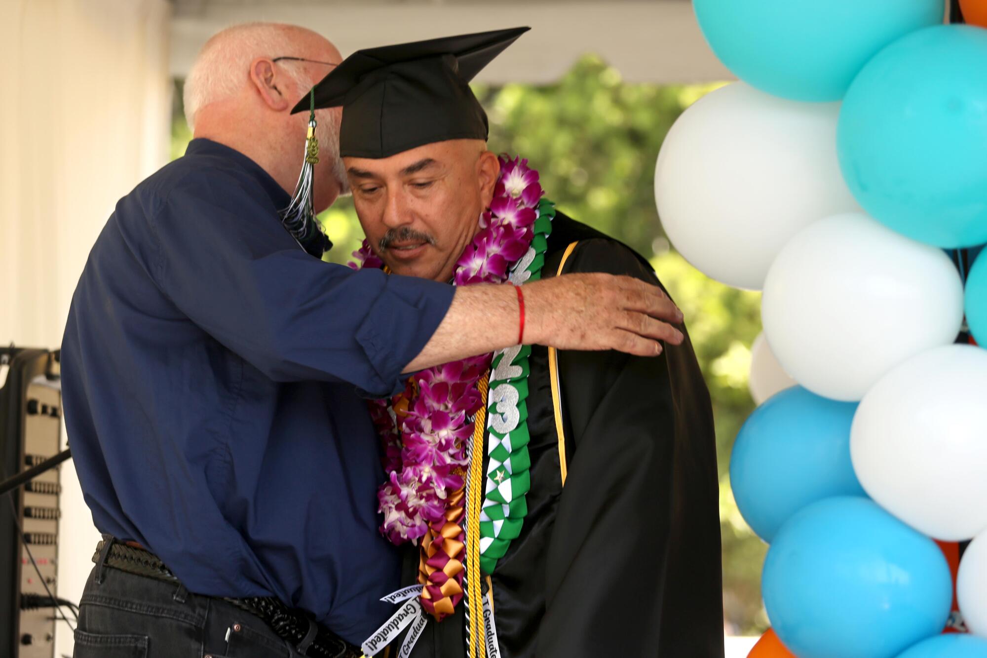Father Greg Boyle hugs graduate Isaac Gonzales.