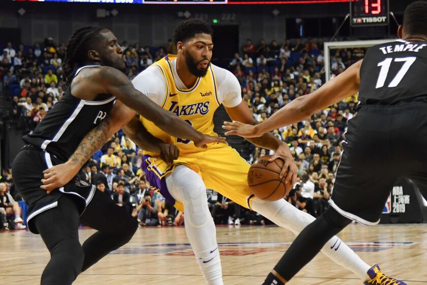 Anthony Davis of Los Angeles Lakers (C) is guarded by Taurean Prince of the Brooklyn Nets (L) during their National Basketball Association (NBA) pre-season match at the Mercedes Benz Arena in Shanghai on October 10, 2019. (Photo by HECTOR RETAMAL / AFP) (Photo by HECTOR RETAMAL/AFP via Getty Images)