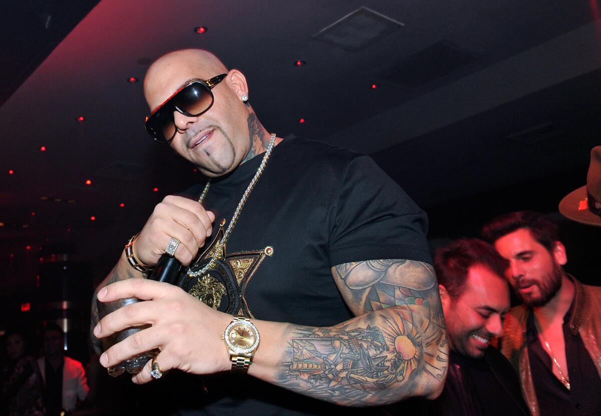 Rapper Mally Mall holds a microphone in a club