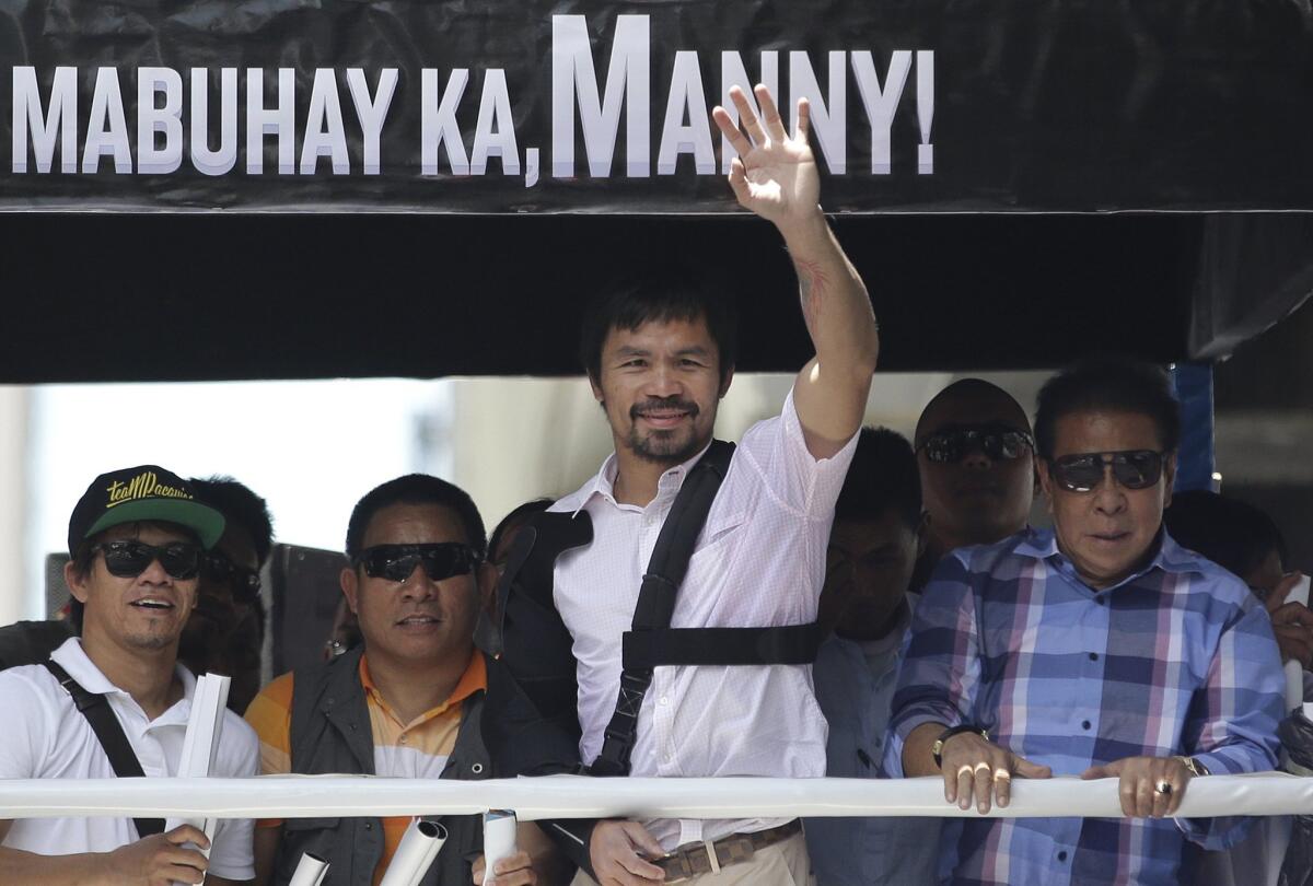 Filipino boxing hero Manny Pacquiao waves during a welcome motorcade May 13 in Manila, Philippines.