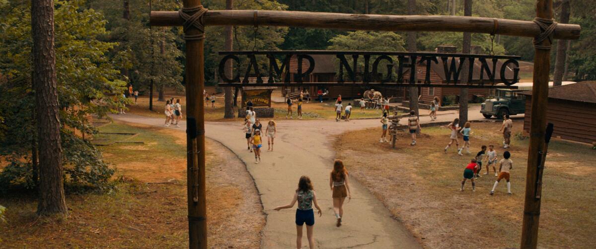 A group of youngsters play beneath a sign that reads "Camp Nightwing."