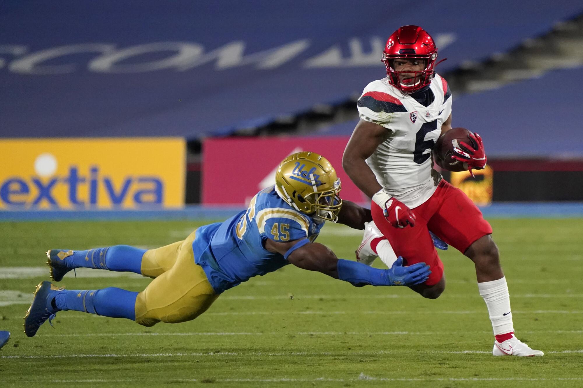 Arizona running back Michael Wiley (6) runs as UCLA linebacker Mitchell Agude (45) makes a tackle 