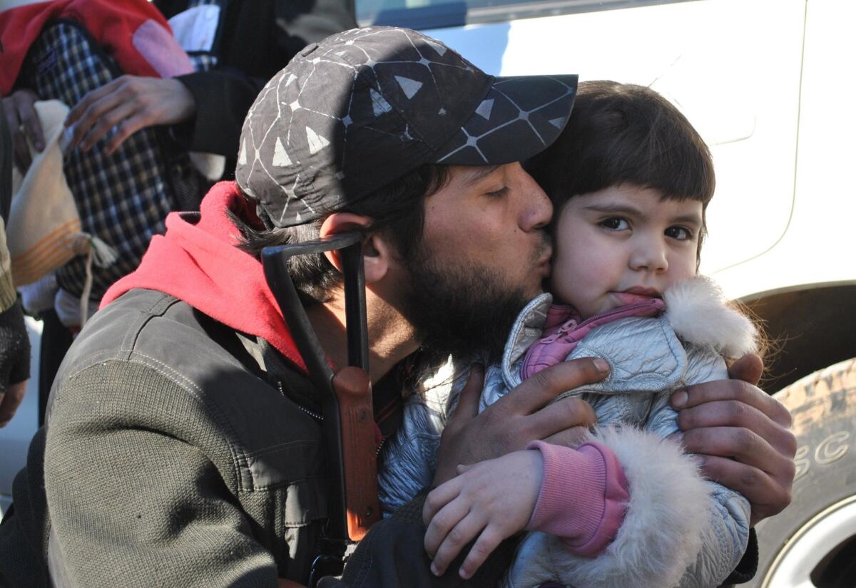 A Syrian rebel fighter says goodbye to a girl Feb. 12 as civilians are evacuated from a besieged district of Homs.