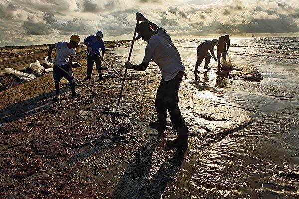 Workers hired by BP rake up globs of oil which have come ashore on the beaches in southern Louisiana, near Port Fourchon and Grand Isle. It coats the beaches and each wave brings a new batch.