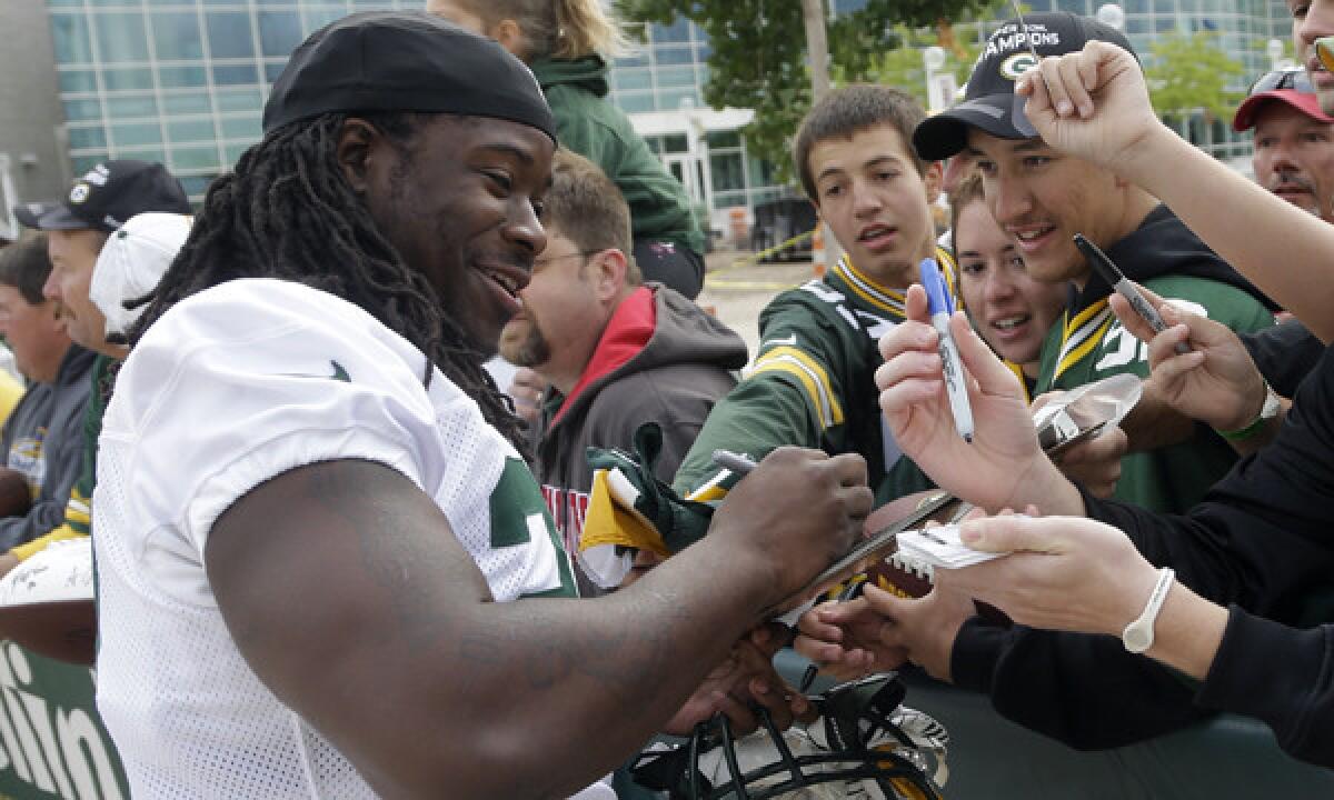Green Bay Packers' Eddie Lacy signs autographs before the start of training camp on Saturday.