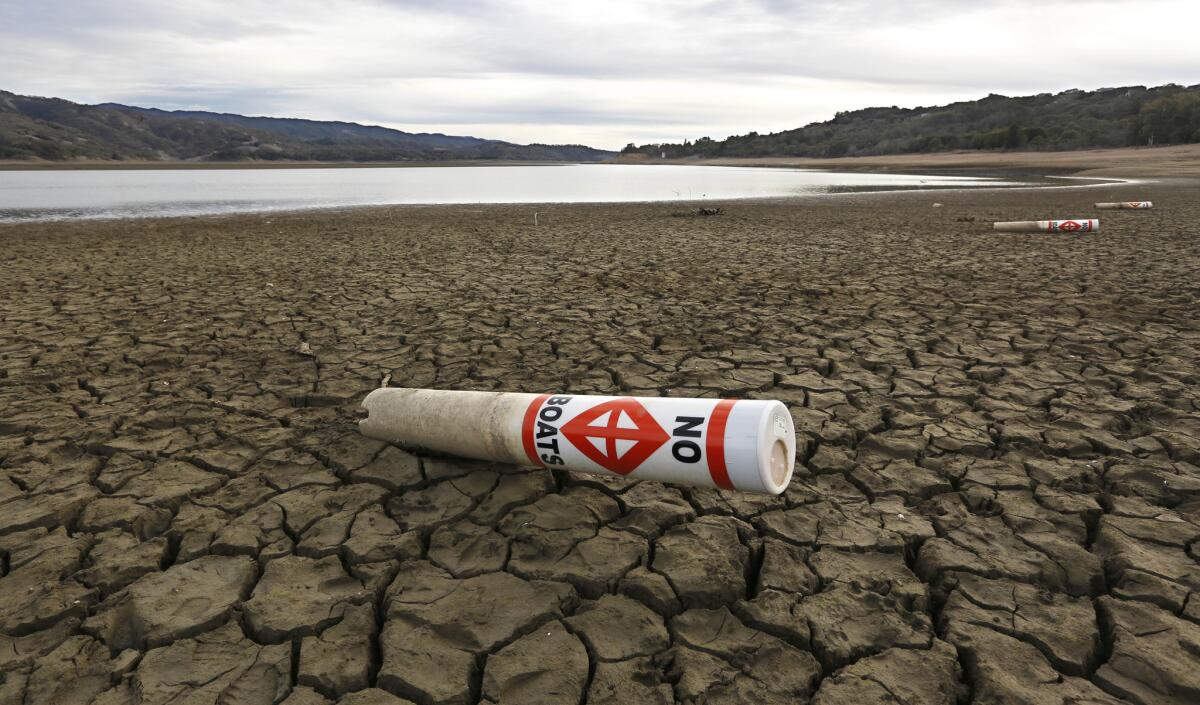 A warning buoy, designed to float in Lake Mendocino near Ukiah, Calif., instead sits on the lake's dry, cracked bed in early 2014.