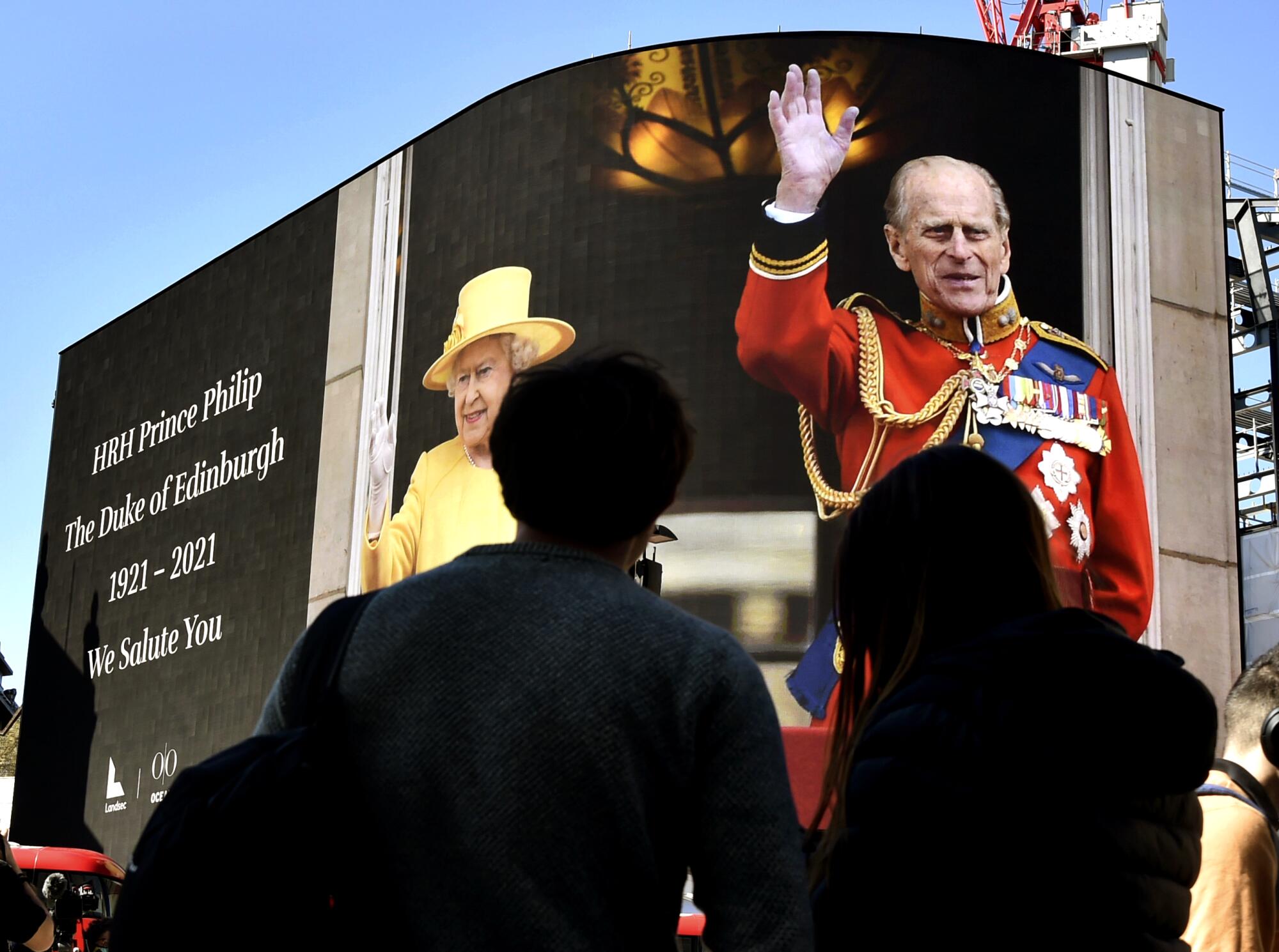 An image of Prince Philip with Queen Elizabeth II is displayed on a giant screen Saturday at Piccadilly Circus in London.