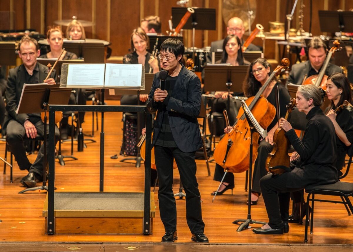 Composer and UC San Diego music professor Lei Liang is shown in Boston in 2018 introducing the world premiere of his "A Thousand Mountains, A Million Streams," which on Monday received one of the most prestigious annual awards in the world of contemporary music.