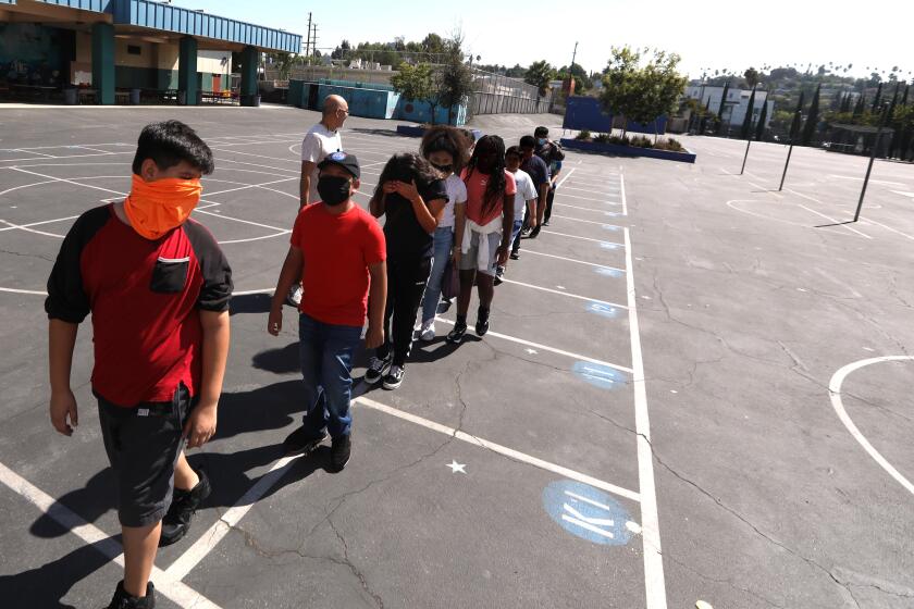 LOS ANGELES, CA - AUGUST 31, 2022 - - Students return to class after a midmorning recess at Lockwood Elementary School on August 31, 2022. With temperatures rising in Los Angeles the principal of the school decided that students would not be allowed to play in the yard in the afternoon due to extreme hot weather. Lockwood Elementary School is the number one school in LAUSD's greening index meaning it is the most in need of green space out of all schools. (Genaro Molina / Los Angeles Times) ATTENTION PRE-PRESS: PLEASE DO NOT LIGHTEN FACES AS TO NOT IDENTIFY STUDENTS.