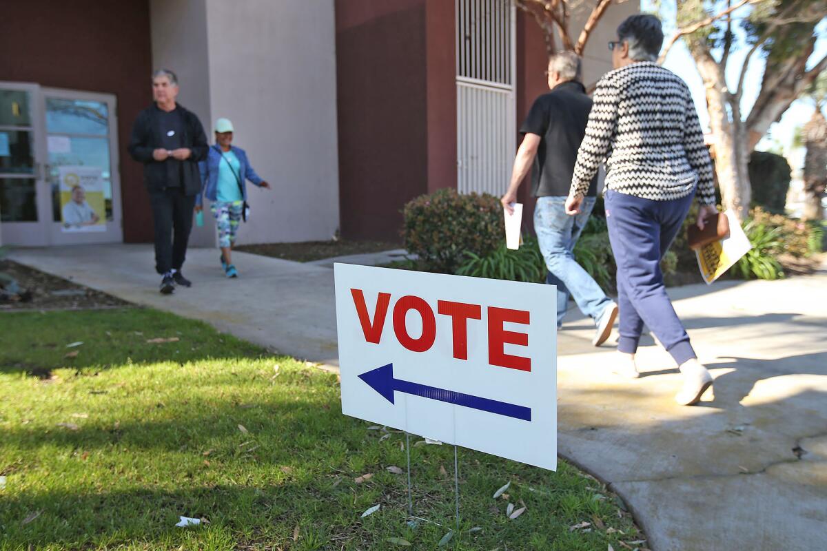 People walk in and out of a voting center at Costa Mesa Senior Center in March 2020.