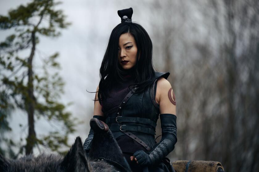 A woman in an all-black, samurai-inspired costume.