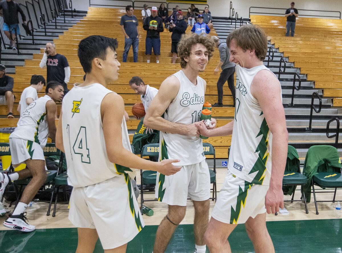 Edison's Jacob Oei, left, and Emerson Evans, center, celebrate with Tyler Hampton after beating Mission Bay on Tuesday.