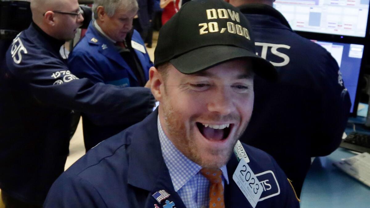 Specialist Frank Masiello wears a "Dow 20,000" cap as he works on the floor of the New York Stock Exchange on Wednesday.
