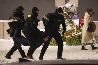 Agentes de policía detienen a un hombre que depositaba flores para Alexei Navalny en un monumento a las víctimas de la represión política, en San Petersburgo, Rusia, el 16 de febrero de 2024. (AP Foto)