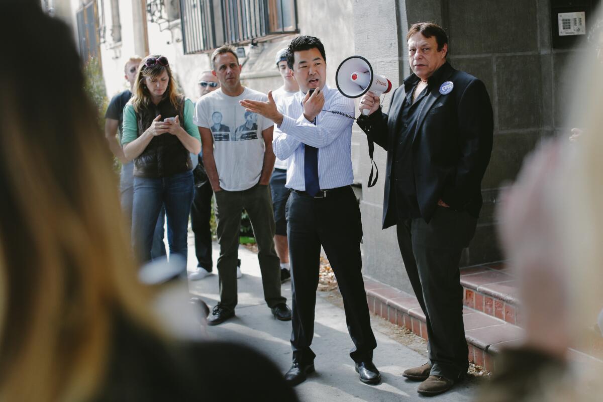 Then-L.A. City Council candidate David Ryu speaks in 2015 at a rally organized by Larry Gross, right, with the Coalition For Economic Survival, for residents of the Villa Carlotta apartment building in Hollywood.