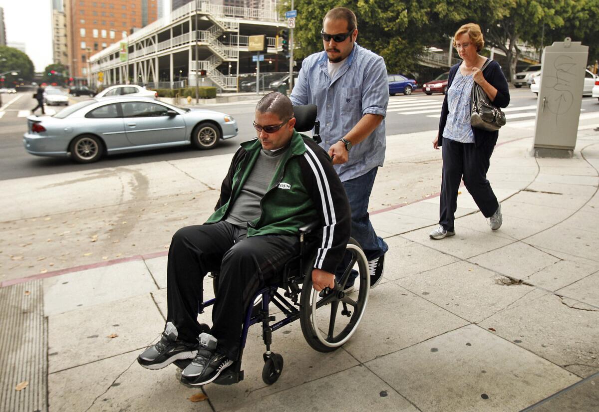 A wheelchair-bound Bryan Stow with his mother, right, enters the Los Angeles Superior Courthouse on May 28.