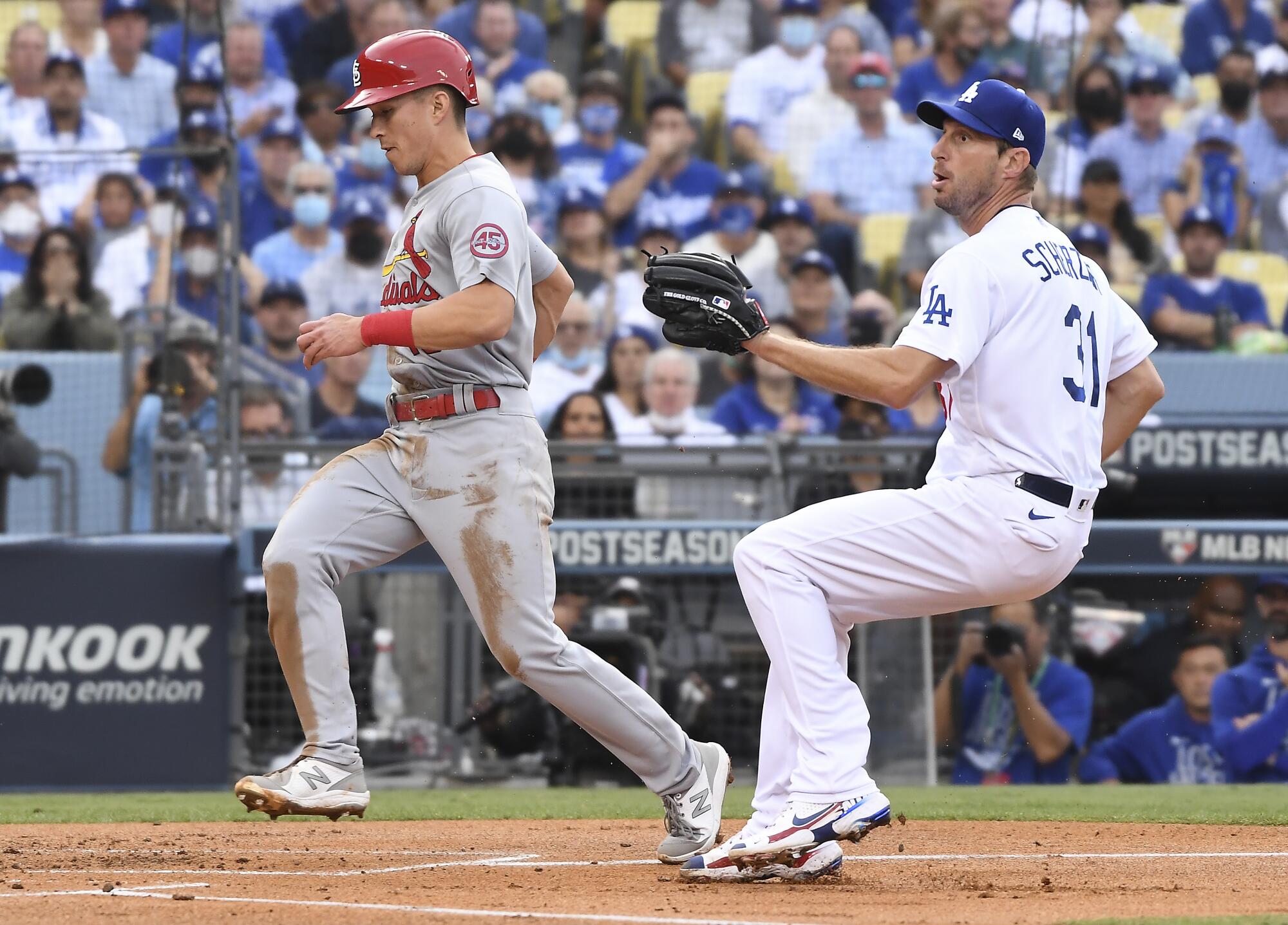 Louis Cardinals' Tommy Edman, left, scores ahead of the catch by Los Angeles Dodgers starting pitcher Max Scherzer
