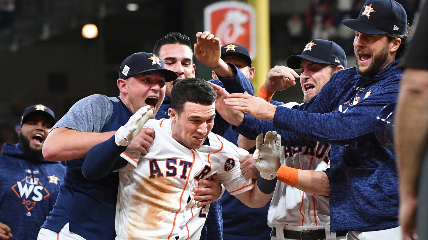 Astros Alex Bregman is mobbed by teamates after hitting the game winner aginst the Dodgers in the 10th inning.