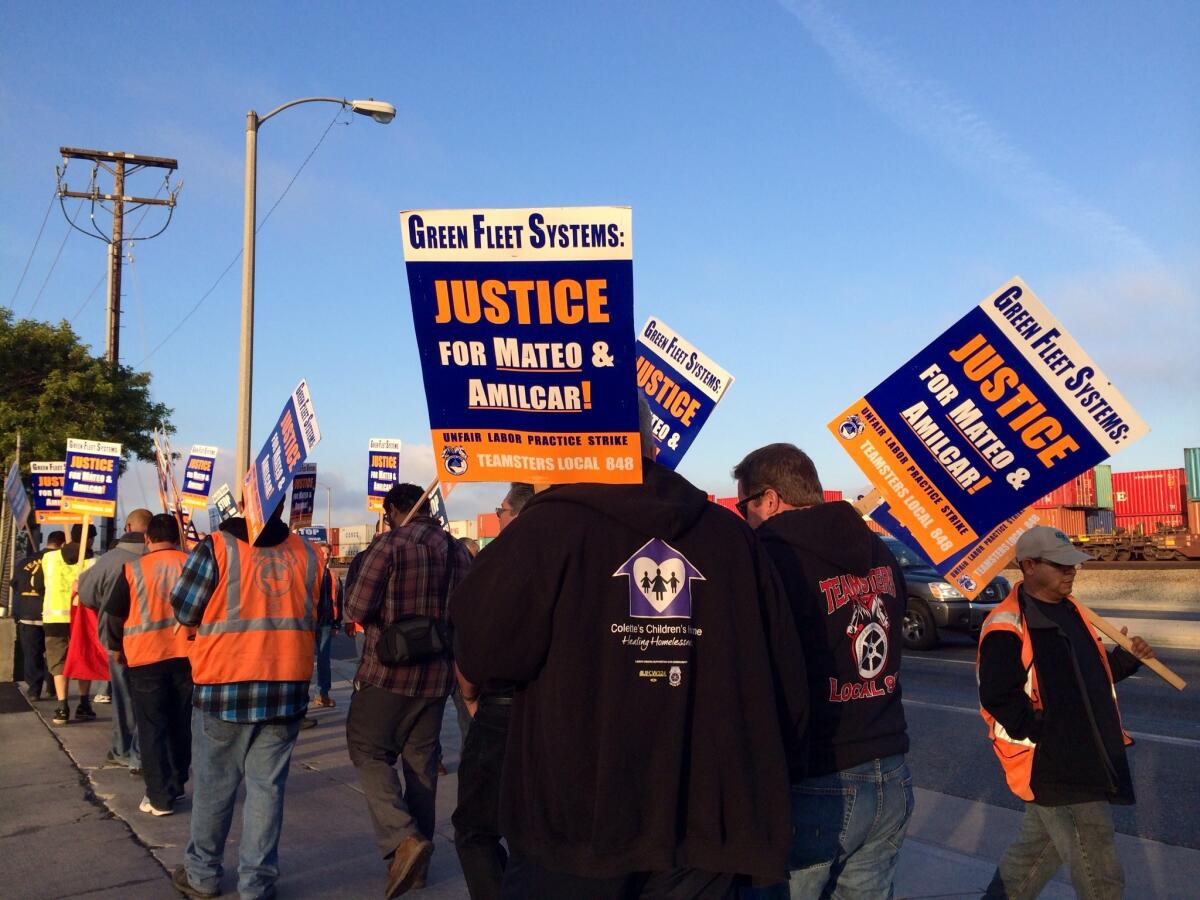 About two dozen truck drivers picket in front of Green Fleet Systems in Carson.