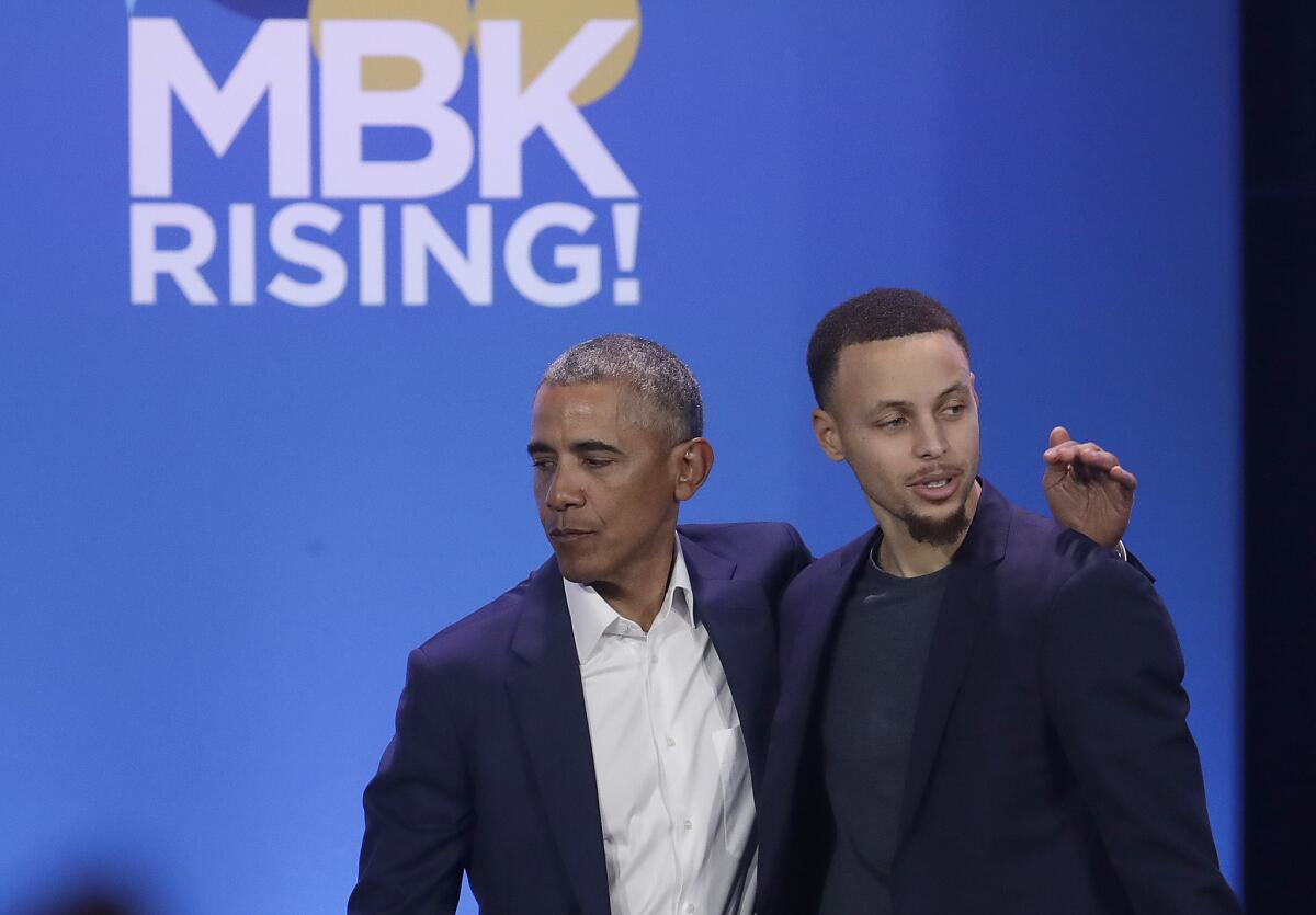 Former President Barack Obama hugs Golden State Warriors star Stephen Curry at the My Brother's Keeper Alliance event in Oakland on Feb. 19, 2019.