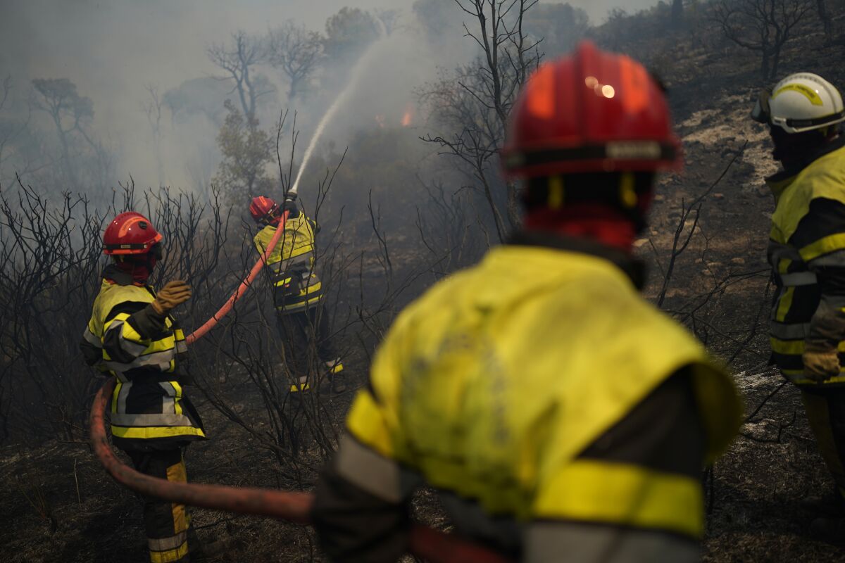 In this photo provided by the fire brigade of the Var region, a fireman battles with a fire near Toulon 