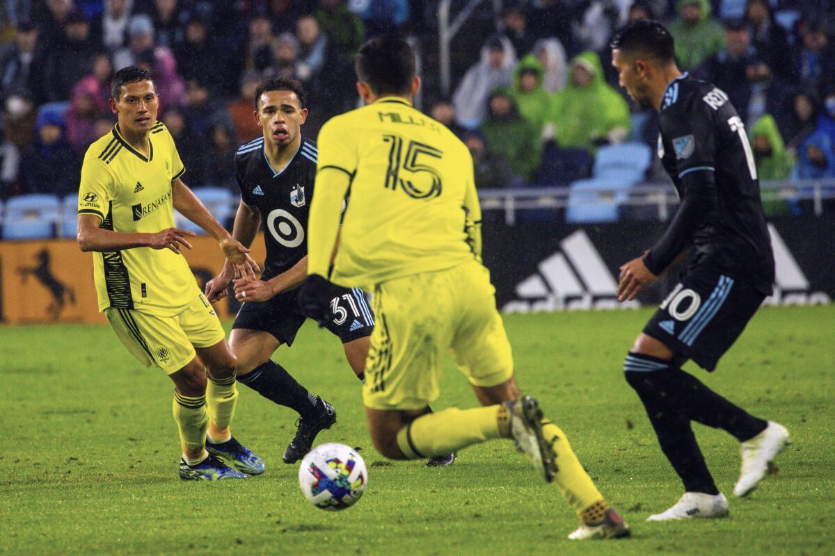 Minnesota United midfielder Hassani Dotson (31) looks for an opening to block Nashville SC defender Eric Miller (15) during the first half of an MLS soccer game, Saturday, March 5, 2022, in Saint Paul, Minn. (AP Photo/Nicole Neri)