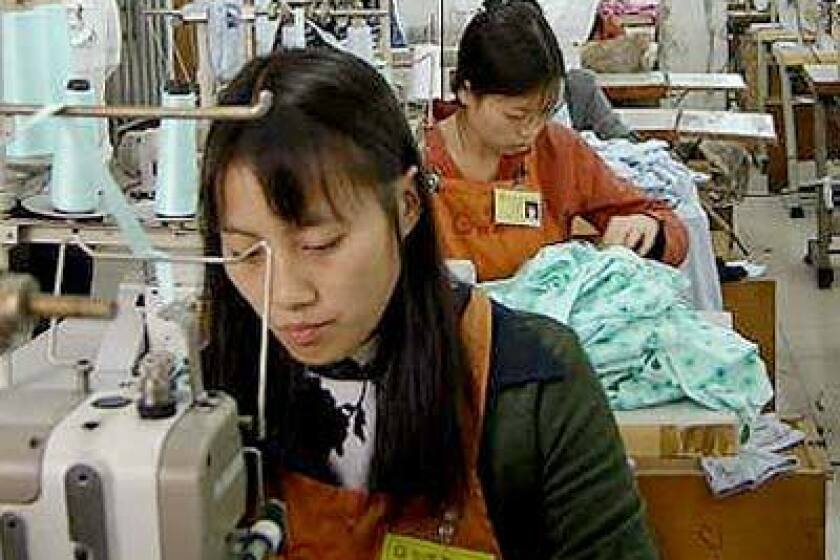 Two Chinese garment workers, Ping Qiu-xia, 20, and Yu Jian-fen, 22, both from Sichuan province, work on an order for Wal-Mart in Germany at the Gladpeer Garment Factory in the southern Chinese city of Dongguan, about 60 miles northwest of Hong Kong.