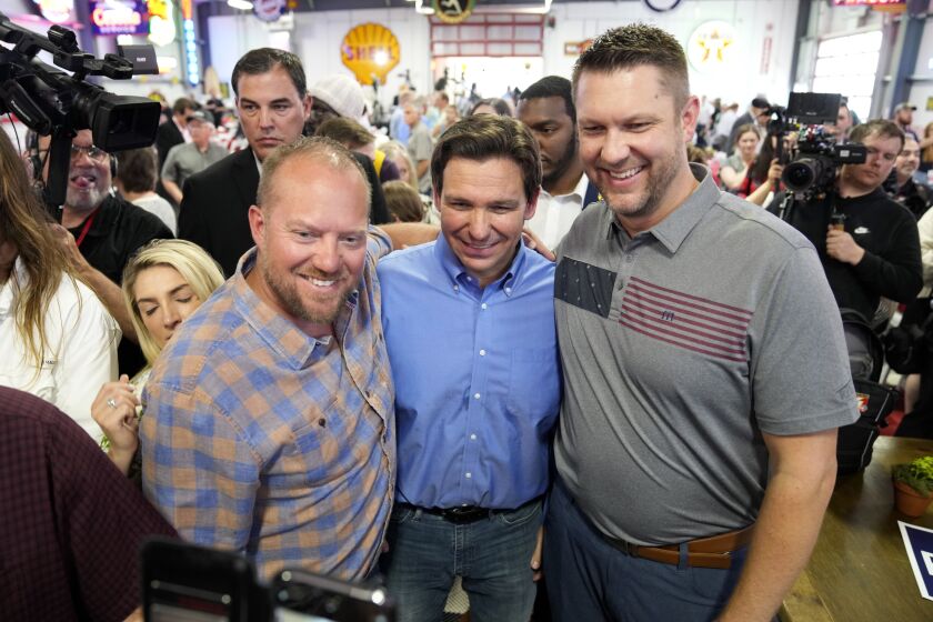 FILE - Florida Gov. Ron DeSantis, center, poses for a photo with audience members during a fundraising picnic forRep. Randy Feenstra, R-Iowa, May 13, 2023, in Sioux Center, Iowa. DeSantis is kicking off his presidential campaign in Iowa at the start of a busy week that will take him to 12 cities in three states as he tests his pitch as the most formidable Republican challenger to former President Donald Trump. (AP Photo/Charlie Neibergall. File)