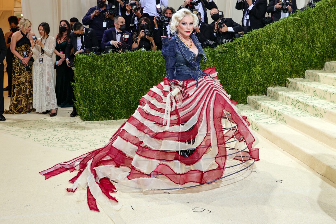 A woman in a flag-stripe gown and blue denim jacket.