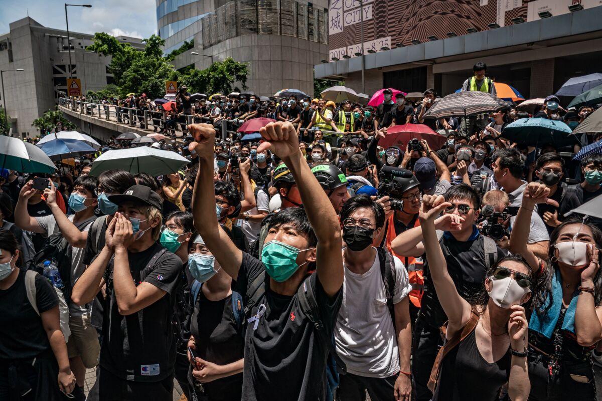 Pro-democracy protesters in Hong Kong shout slogans outside police headquarters in June 2019.