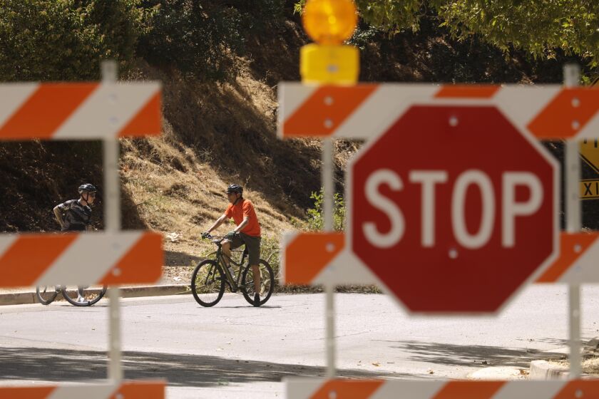 LOS ANGELES, CA - JUNE 29, 2022 - - Bicyclists enjoy a conversation while taking a break from a ride along a one-third mile portion of Griffith Park Drive that is indefinitely closed to car traffic to improve safety for pedestrians and cyclists in Griffith Park in Los Angeles on June 29, 2022. The road is known to draw high-speed drivers who are looking for a shortcut, avoiding the 134 and 5 freeways. The temporary closure has been in place since Monday, June 27 and will carry on indefinitely until more permanent changes to the park's infrastructure are in place. (Genaro Molina / Los Angeles Times)