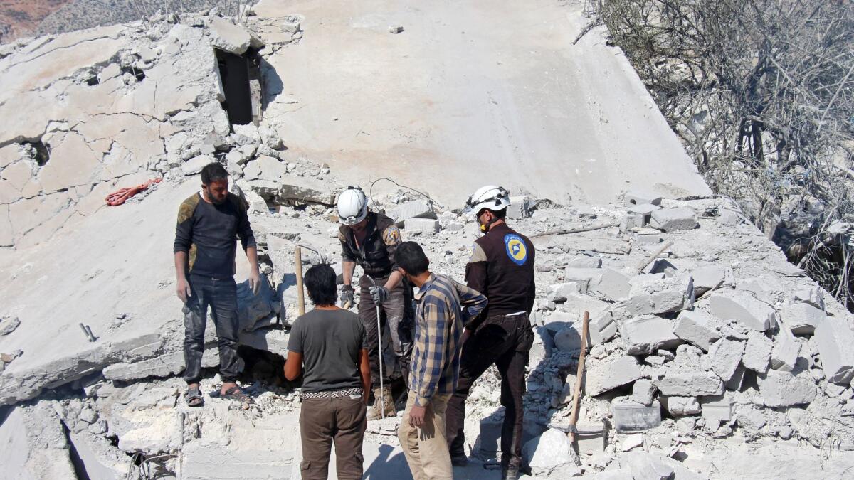Volunteers with the Syria Civil Defense, known as the "White Helmets," search for survivors in the rubble after an airstrike in Armanaz, a rural area of Syria's Idlib province, on Sept. 30, 2017.