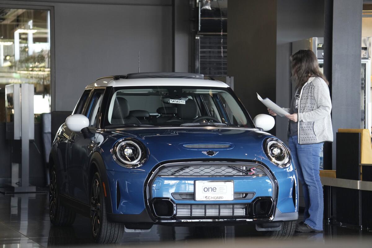 A person stands beside a vehicle. 