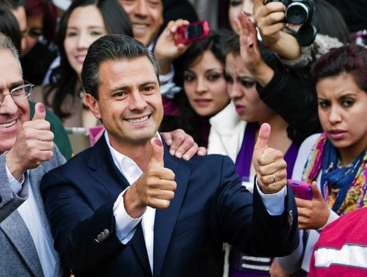 Enrique Peña Nieto shows his ink-stained thumbs after voting in the presidential election in July. His victory returns the long-ruling PRI to power.