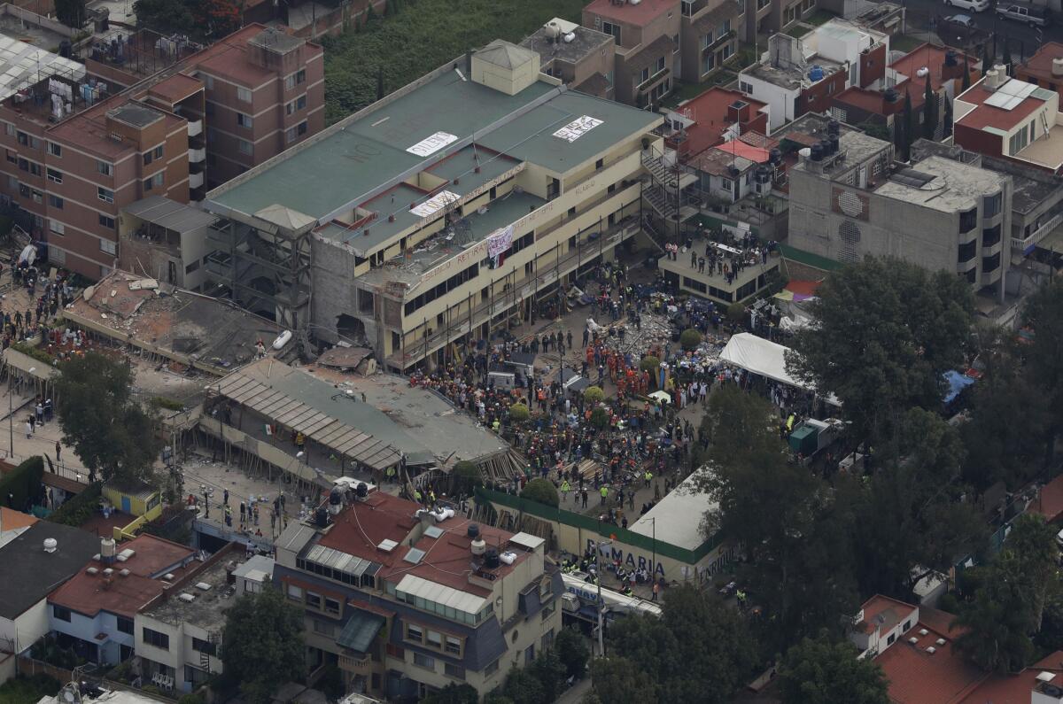 Volunteers and rescue workers search for children and others trapped inside the Enrique Rebsamen school in Mexico City. (Rebecca Blackwell / Associated Press)