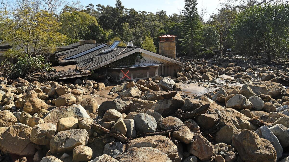 A house sits among boulders and mud along Glen Oaks Drive in Montecito on Jan. 10 after a major storm hit the area.