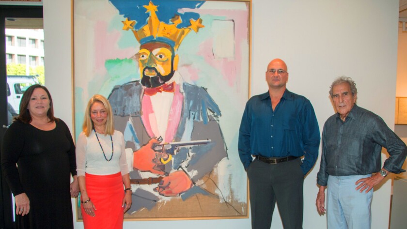 At the Aug. 31 reception at Tasende Gallery in La Jolla: José Tasende (far right) poses with his daughter Betina (far left), gallery director Mary Beth Petersen, and his son Aitor. Behind them is ‘American Crown,’ a painting by German artist Lambert Maria Wintersberger.