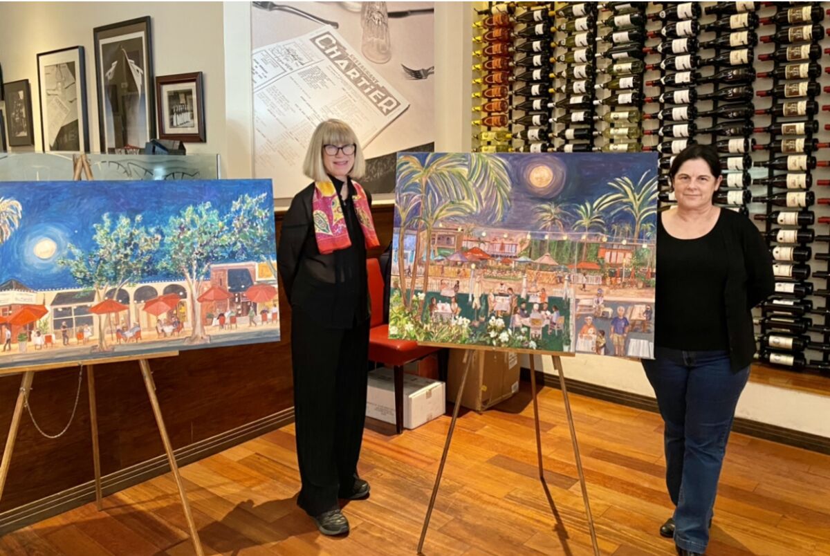 La Jollan Paula McColl, left, with Bistrot du Marché owner Sylvie Diot and two of the three paintings on exhibit Oct. 13.