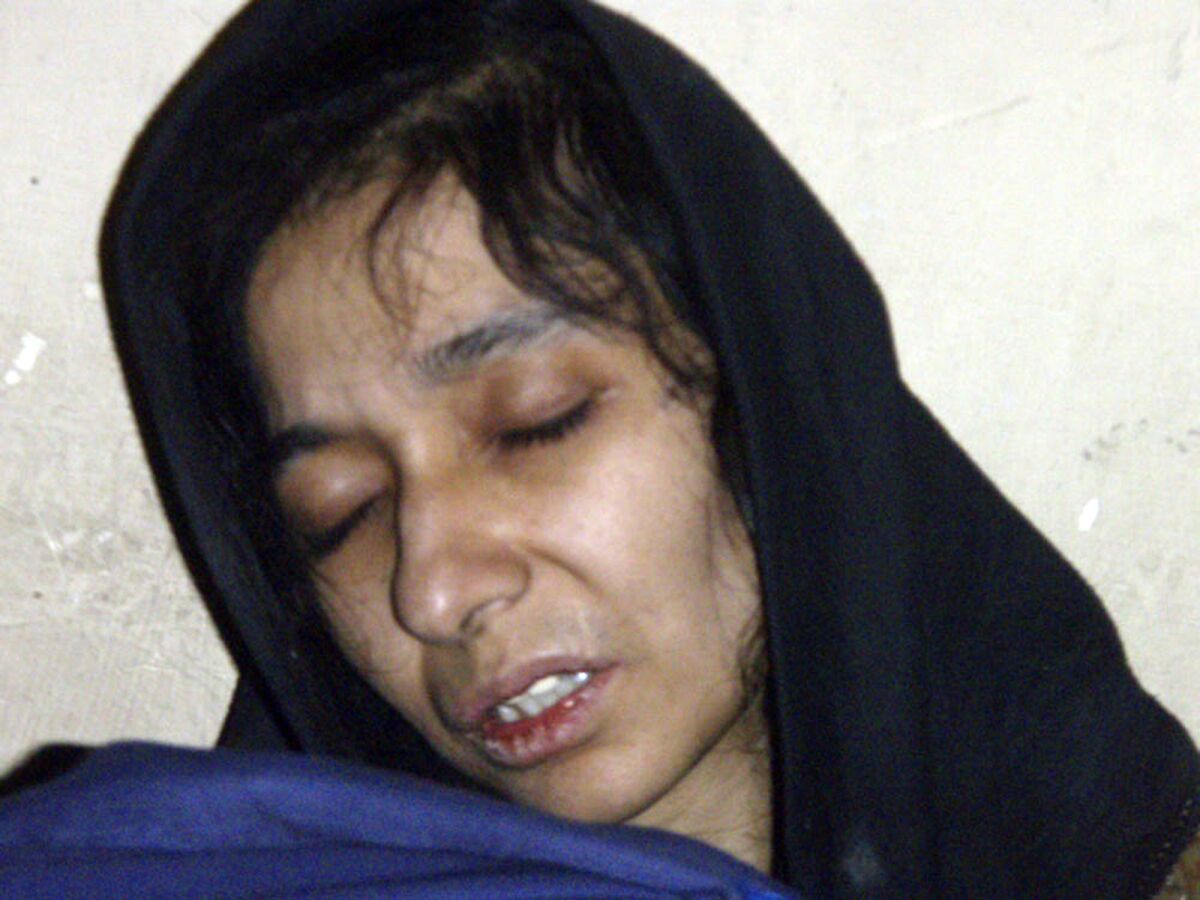 FILE - In this July 17, 2008, file photo, Aafia Siddiqui, possible al-Qaida associate, is seen in the custody of Counter Terrorism Department of Ghazni province in Ghazni City, Afghanistan. The man who authorities say was holding hostages inside a Texas synagogue on Saturday, Jan. 15, 2022, demanded the release of Aafia Siddiqui, a Pakistani woman who is imprisoned on charges of trying to kill American service members in Afghanistan. (AP Photo/ File)