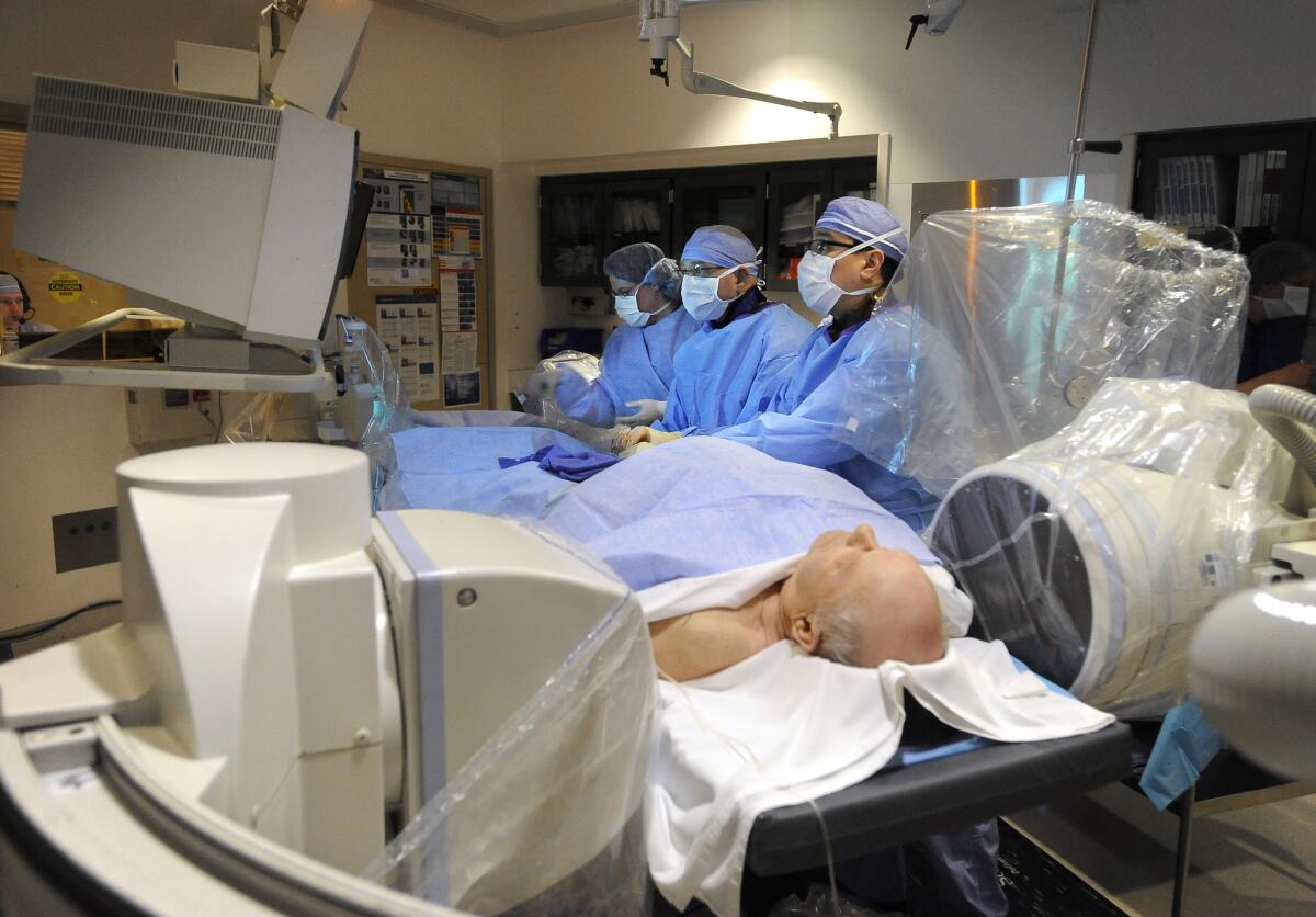 A surgical team operates on a man.
